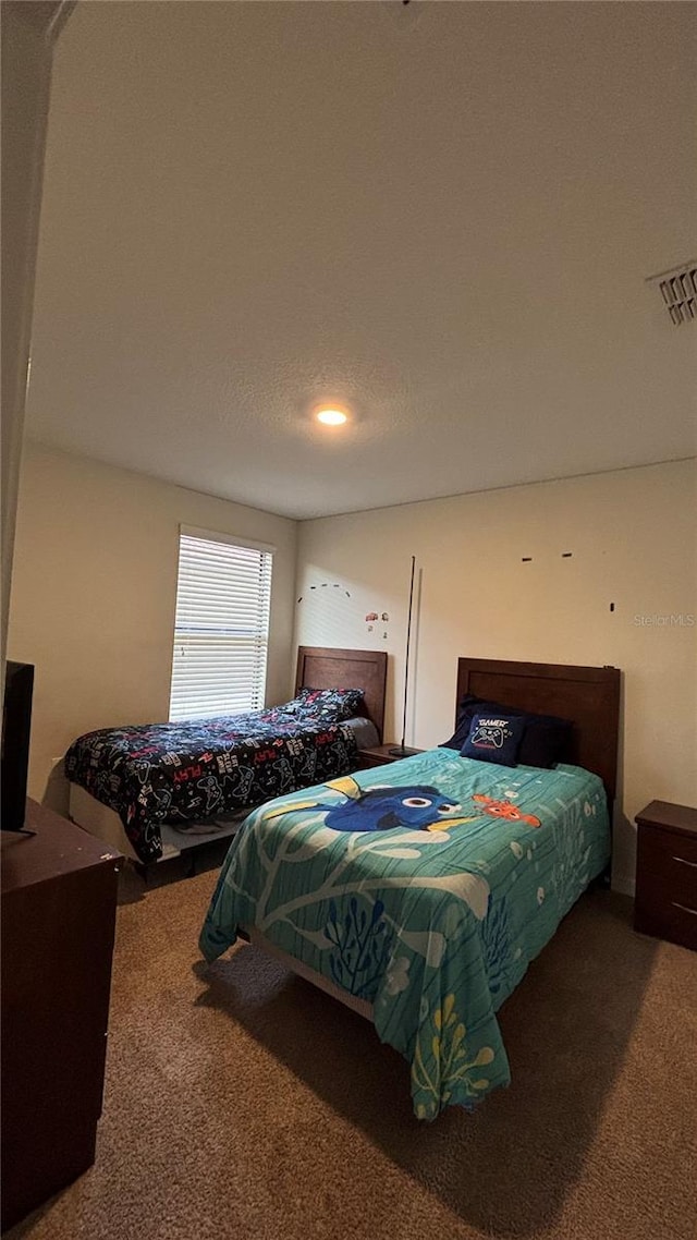 carpeted bedroom featuring visible vents