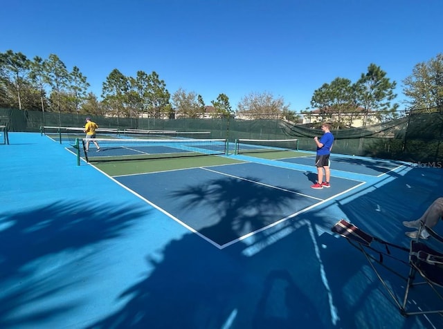 view of tennis court featuring fence