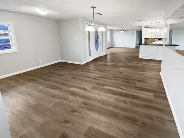 interior space with dark wood-type flooring, visible vents, baseboards, and ceiling fan