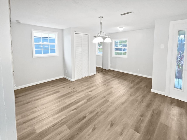 empty room with visible vents, baseboards, and wood finished floors