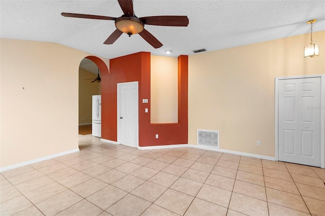 unfurnished room featuring visible vents, arched walkways, a textured ceiling, and vaulted ceiling