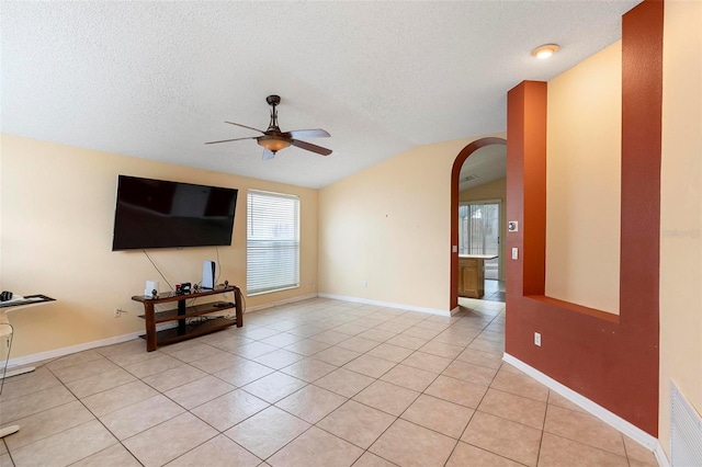 unfurnished living room with light tile patterned floors, visible vents, arched walkways, vaulted ceiling, and a textured ceiling