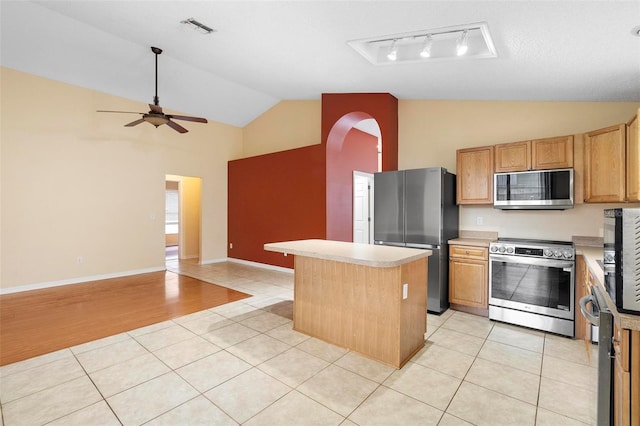 kitchen featuring visible vents, a center island, appliances with stainless steel finishes, light tile patterned flooring, and light countertops