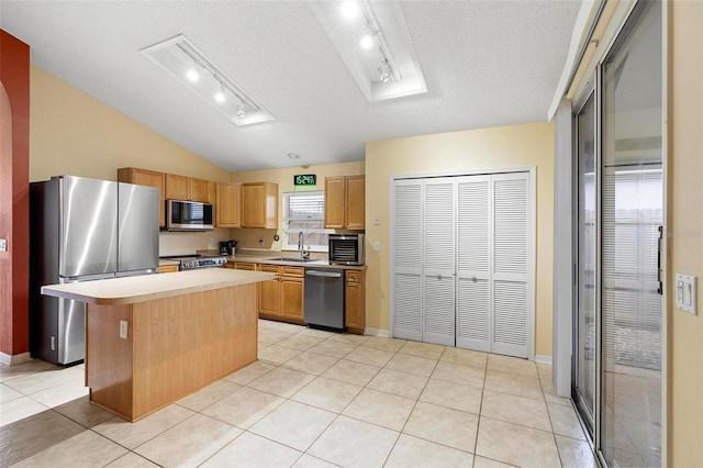 kitchen with light countertops, light tile patterned floors, appliances with stainless steel finishes, a textured ceiling, and a sink