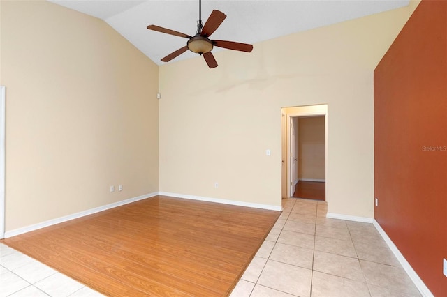 unfurnished room featuring light tile patterned flooring, baseboards, lofted ceiling, and a ceiling fan