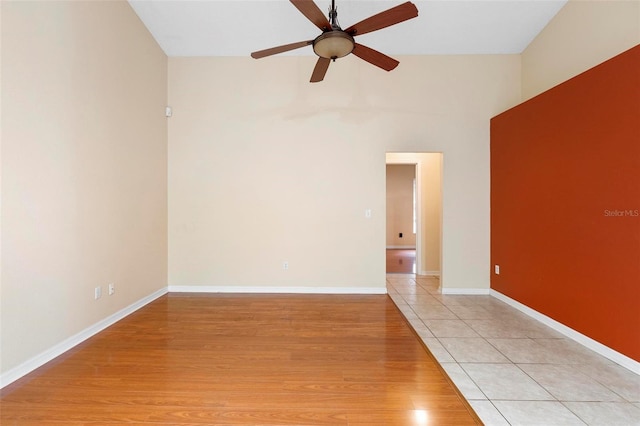 spare room with a ceiling fan, baseboards, and light wood finished floors