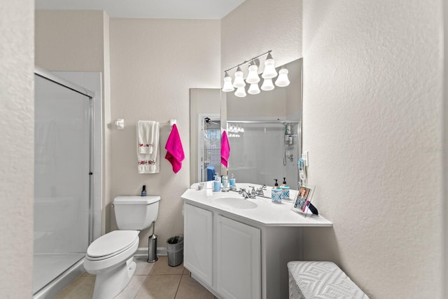 bathroom featuring tile patterned floors, vanity, toilet, and a shower stall
