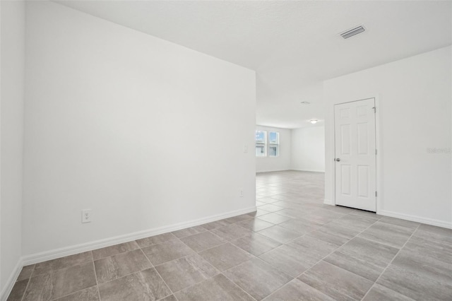 unfurnished room with visible vents, baseboards, and light tile patterned flooring