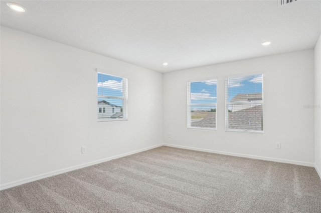 empty room with baseboards, carpet, and recessed lighting