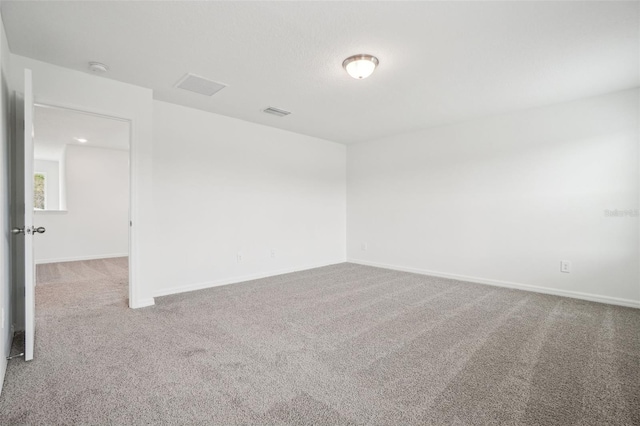 carpeted spare room with baseboards and visible vents