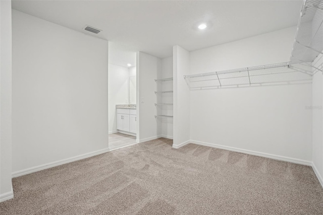 walk in closet featuring light colored carpet and visible vents