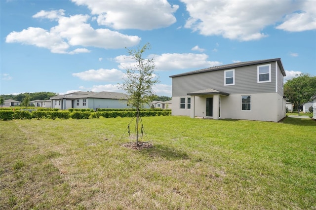 rear view of property featuring a lawn