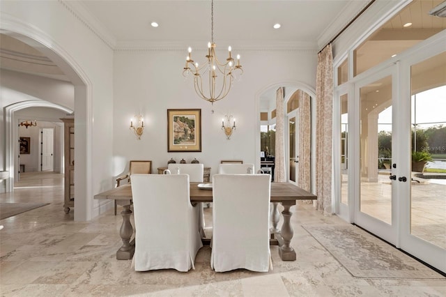 dining room with arched walkways, french doors, crown molding, and an inviting chandelier