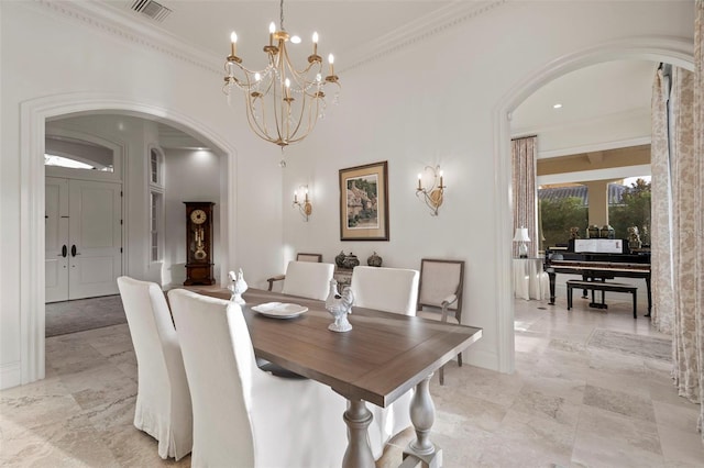 dining room with visible vents, baseboards, ornamental molding, an inviting chandelier, and arched walkways