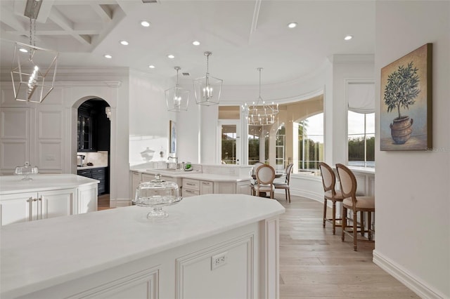 bathroom with recessed lighting, wood finished floors, an inviting chandelier, and ornamental molding