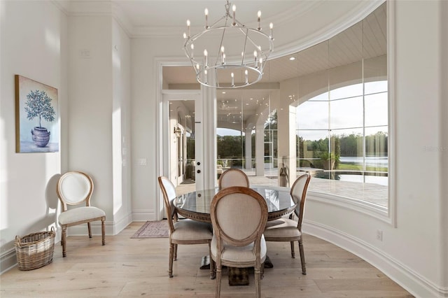 dining space with baseboards, light wood-type flooring, an inviting chandelier, and ornamental molding