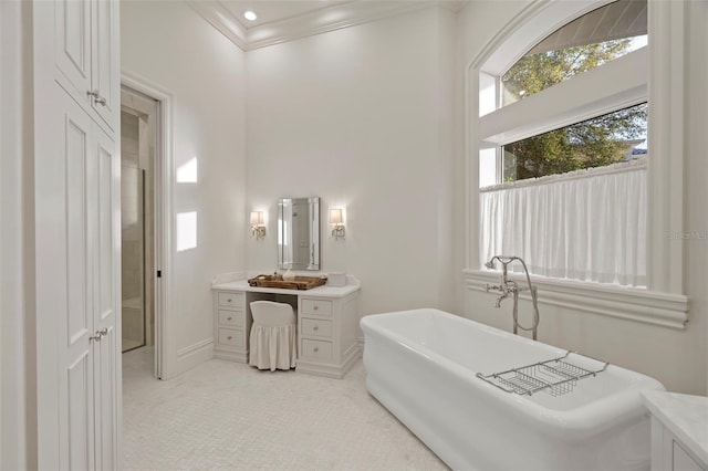 bathroom featuring a soaking tub, vanity, and crown molding