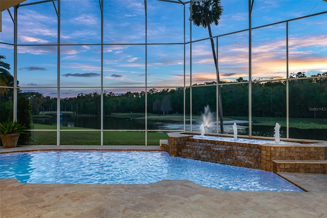 view of pool with glass enclosure and a patio area