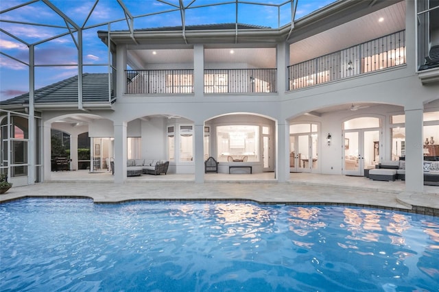 rear view of property featuring a patio area, an outdoor hangout area, french doors, and a balcony