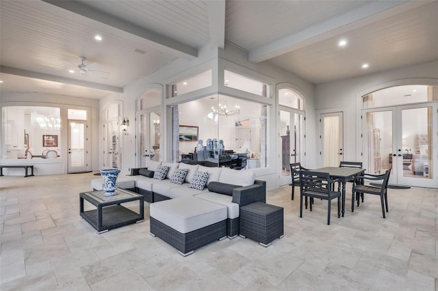 living room with stone finish flooring, beam ceiling, recessed lighting, french doors, and ceiling fan with notable chandelier