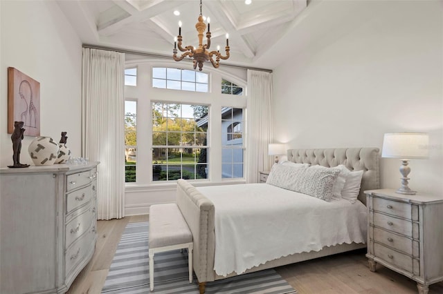 bedroom with beamed ceiling, coffered ceiling, light wood-type flooring, and an inviting chandelier