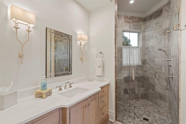 bathroom with vanity, a shower stall, and ornamental molding