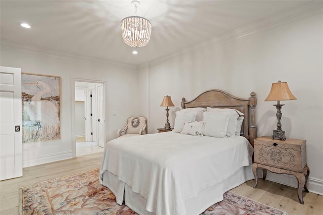 bedroom featuring baseboards, a notable chandelier, wood finished floors, and crown molding