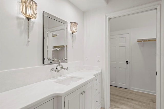 bathroom with vanity, a notable chandelier, and wood finished floors