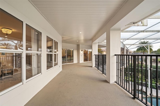 view of patio / terrace featuring a lanai, a balcony, and an outdoor pool