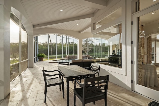 sunroom featuring beam ceiling