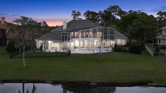 back of property with a fenced in pool, fence, glass enclosure, a chimney, and a yard