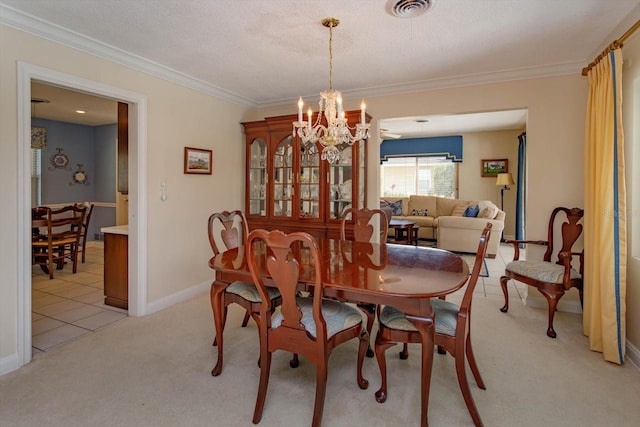 dining area featuring visible vents, an inviting chandelier, crown molding, baseboards, and light colored carpet