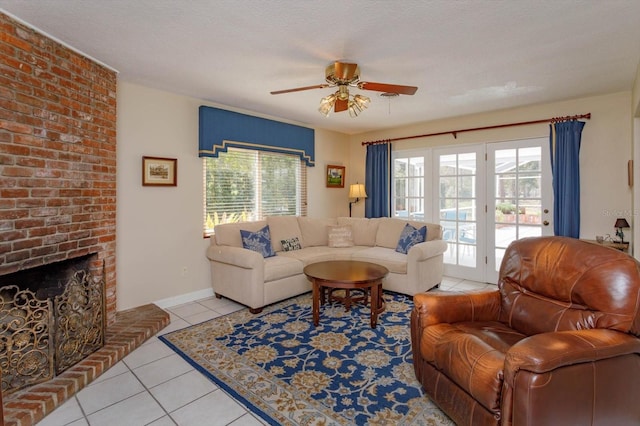 living area featuring light tile patterned floors, a healthy amount of sunlight, a brick fireplace, and a ceiling fan