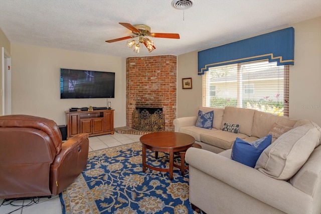 living area featuring visible vents, a brick fireplace, light tile patterned floors, a textured ceiling, and a ceiling fan