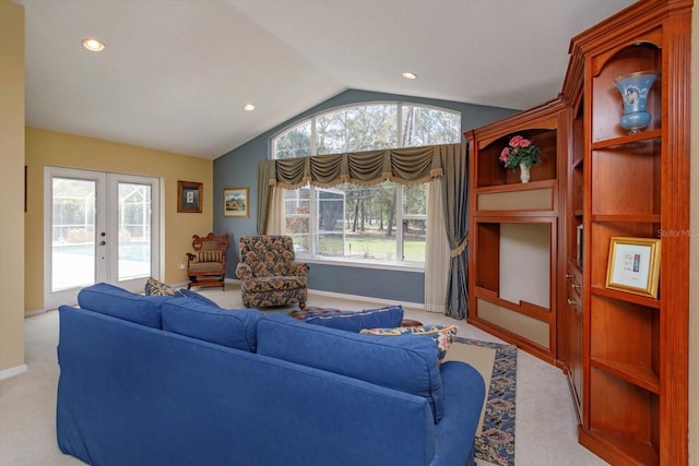 living area featuring lofted ceiling, plenty of natural light, french doors, and light colored carpet