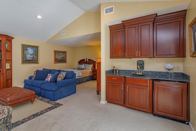 kitchen featuring visible vents, light colored carpet, open floor plan, and vaulted ceiling