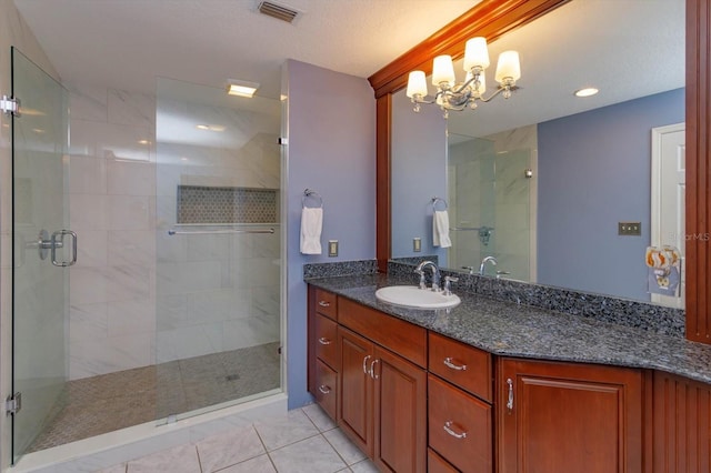 full bath with vanity, tile patterned floors, visible vents, and a stall shower