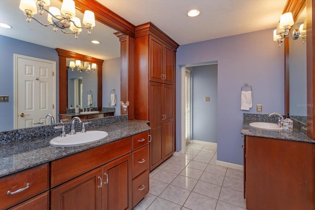 bathroom with tile patterned floors, two vanities, a chandelier, and a sink