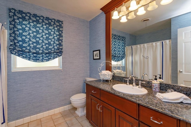 bathroom with tile patterned flooring, curtained shower, baseboards, toilet, and vanity