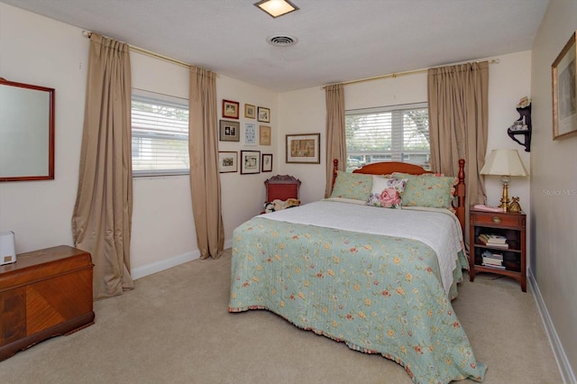 bedroom with visible vents, multiple windows, baseboards, and carpet