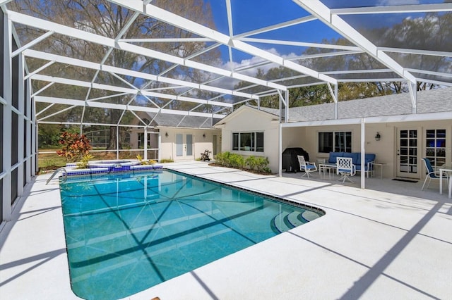 outdoor pool featuring glass enclosure, an in ground hot tub, french doors, and a patio