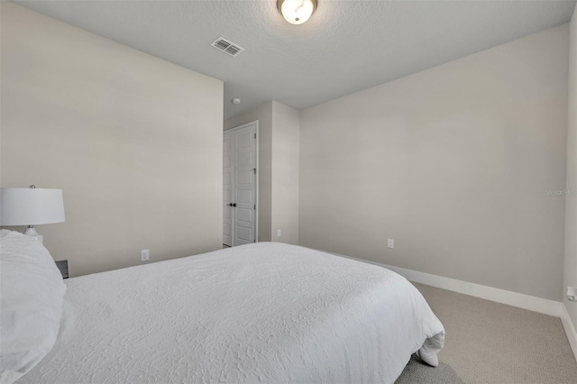 bedroom featuring baseboards, visible vents, carpet floors, and a textured ceiling