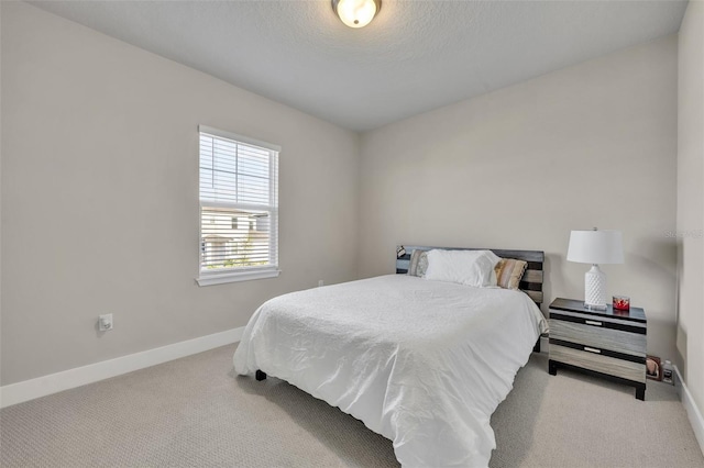 bedroom featuring baseboards, carpet floors, and a textured ceiling