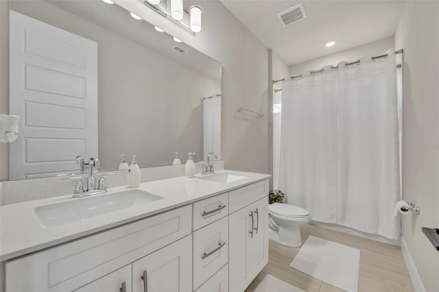 full bathroom with a sink, visible vents, and toilet