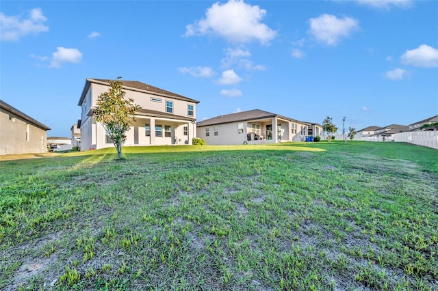 rear view of property featuring stucco siding and a lawn