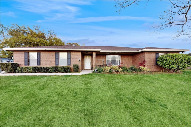 single story home with brick siding and a front yard