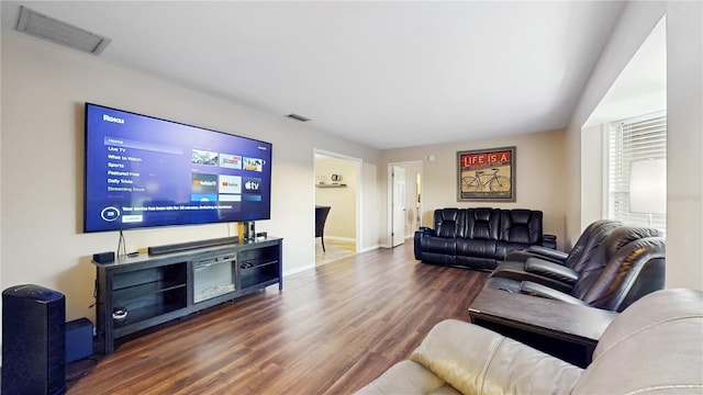 living room featuring visible vents, baseboards, and dark wood-style flooring