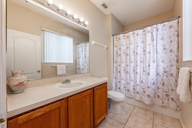 full bath featuring visible vents, toilet, vanity, tile patterned floors, and a textured ceiling