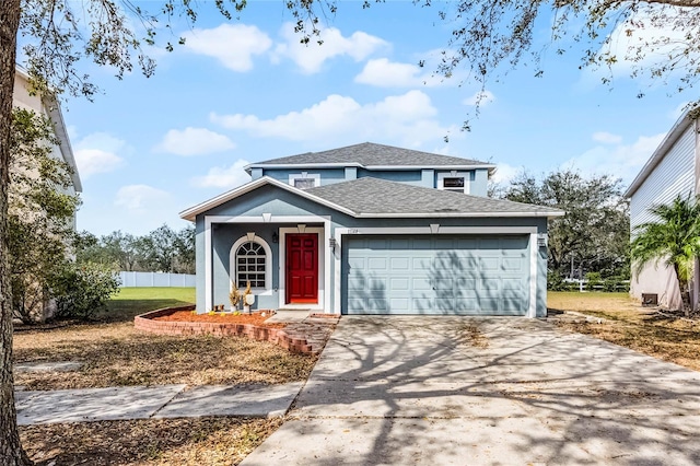 traditional-style house featuring fence, roof with shingles, an attached garage, stucco siding, and concrete driveway