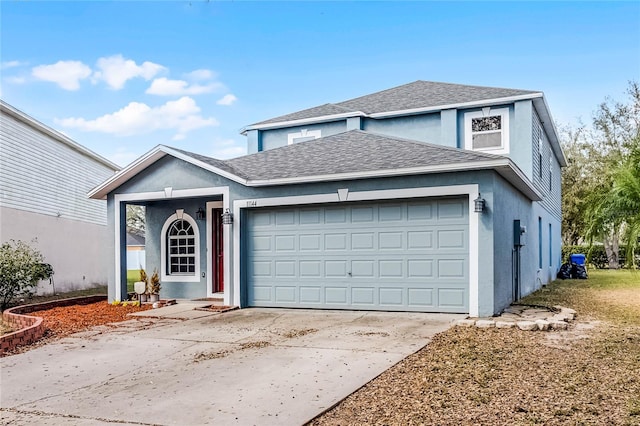 traditional home with stucco siding, an attached garage, concrete driveway, and roof with shingles